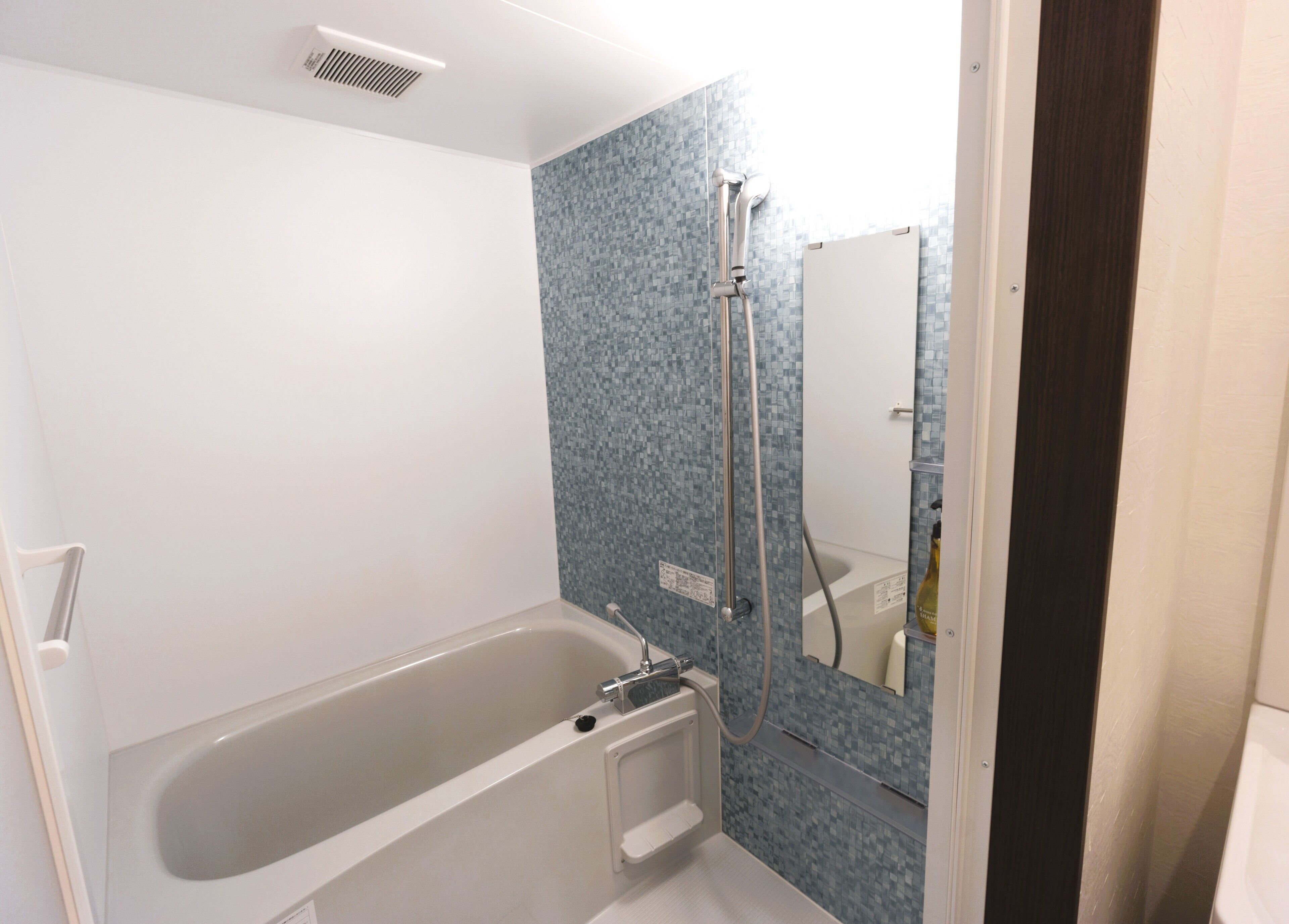 A bathroom with a bathtub, a shower, and a tiled wall.