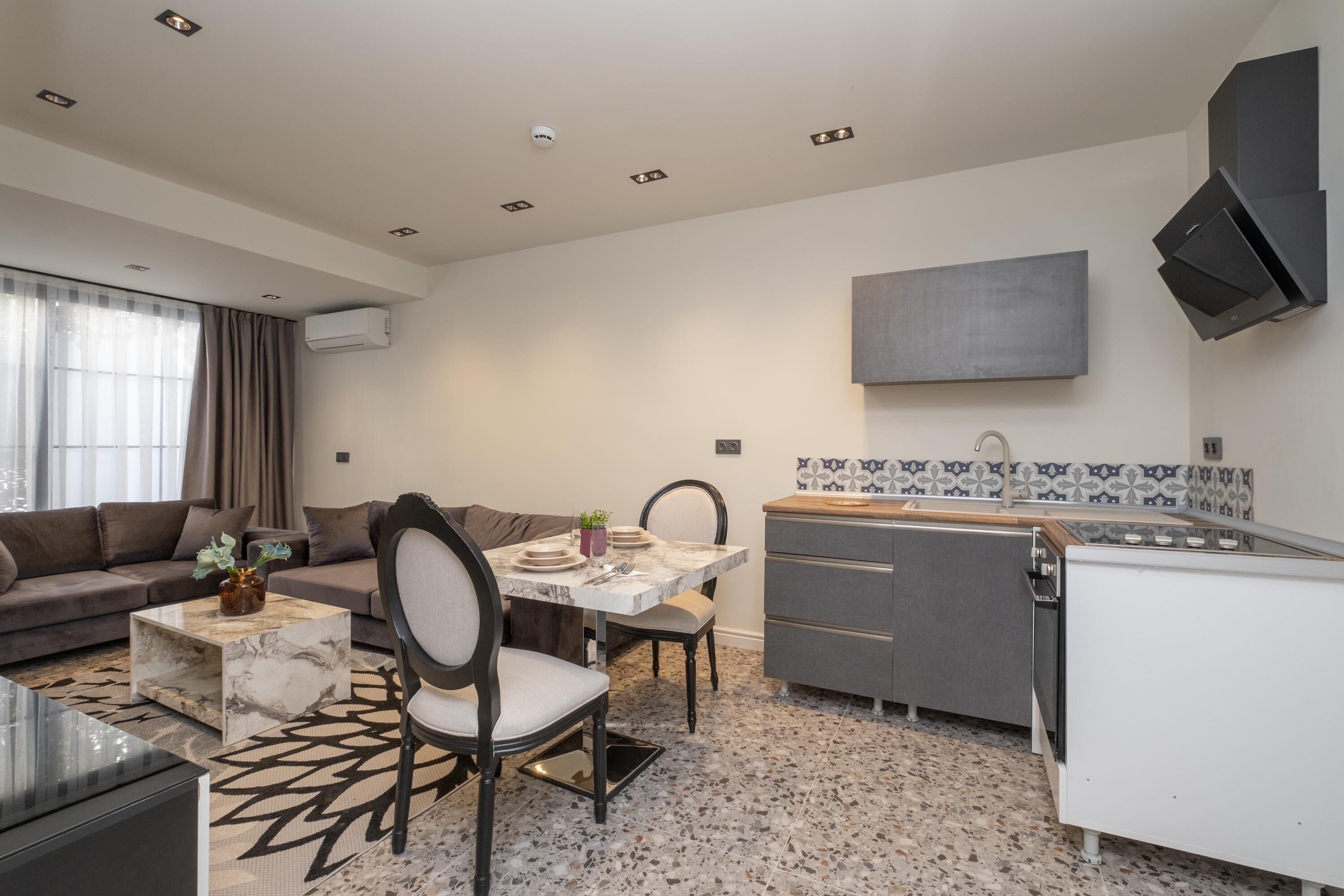Un espace de vie compact comprenant un coin repas, un canapé et une kitchenette.