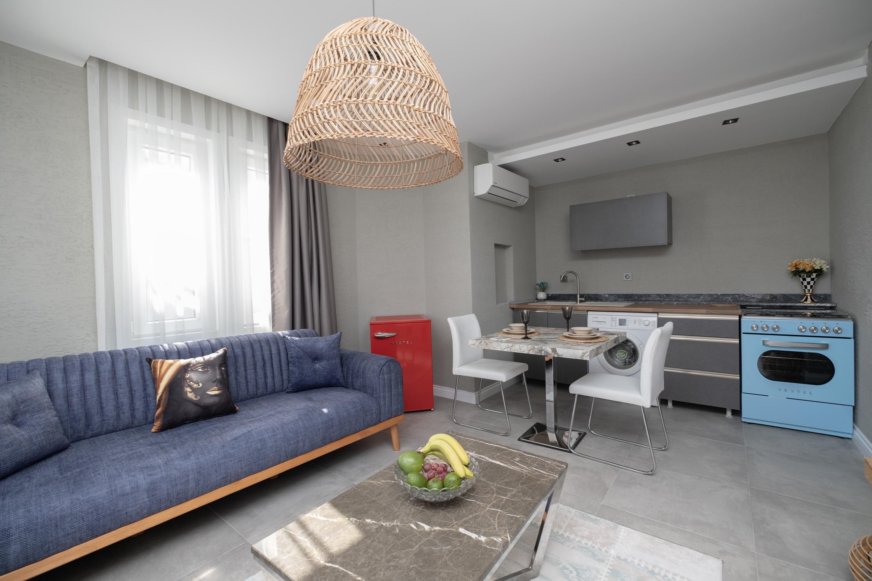 Uma sala de estar moderna com sofá, mesa de centro e área de jantar.