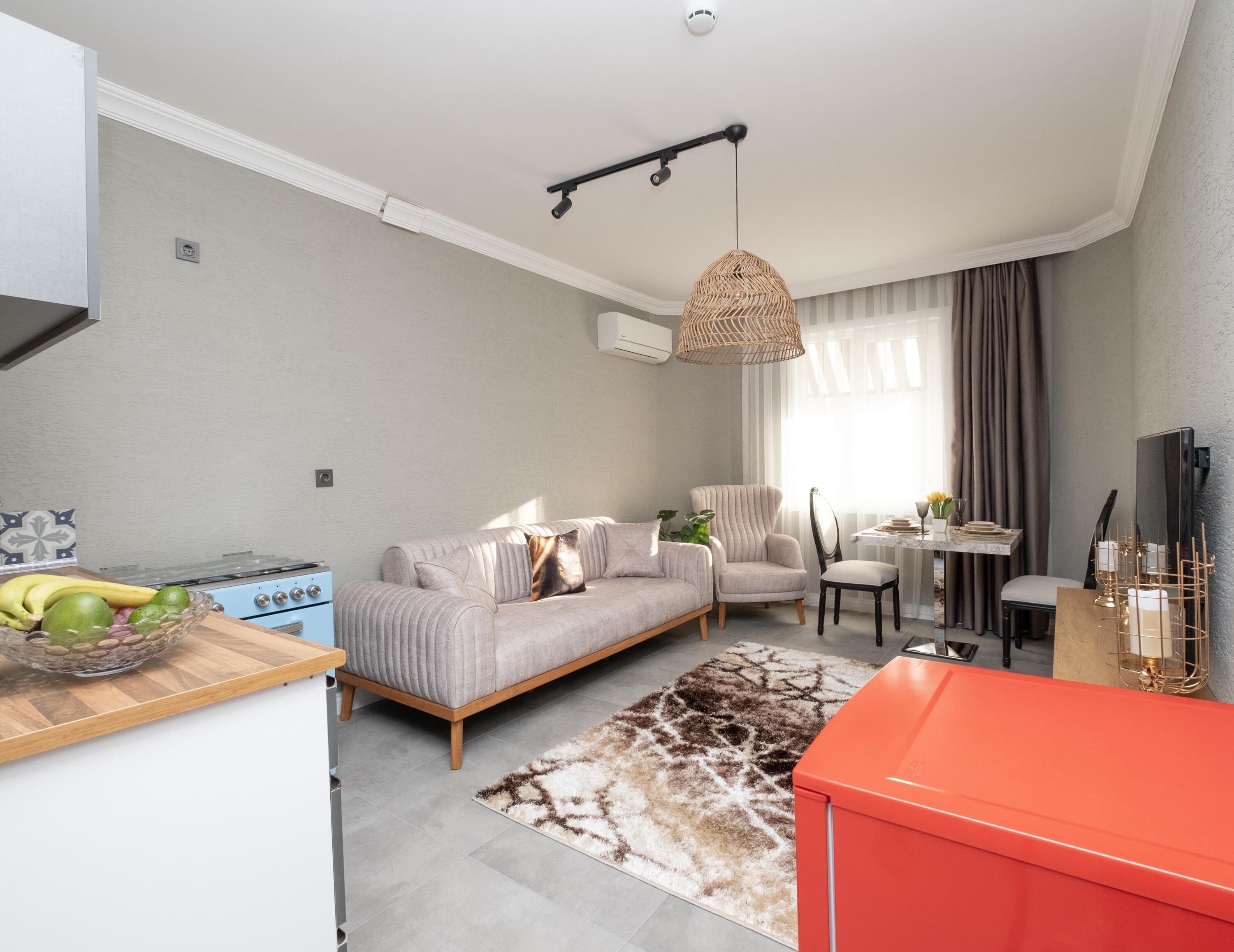 Una sala moderna con un sofá, una mesa de comedor y una zona de cocina con estufa.