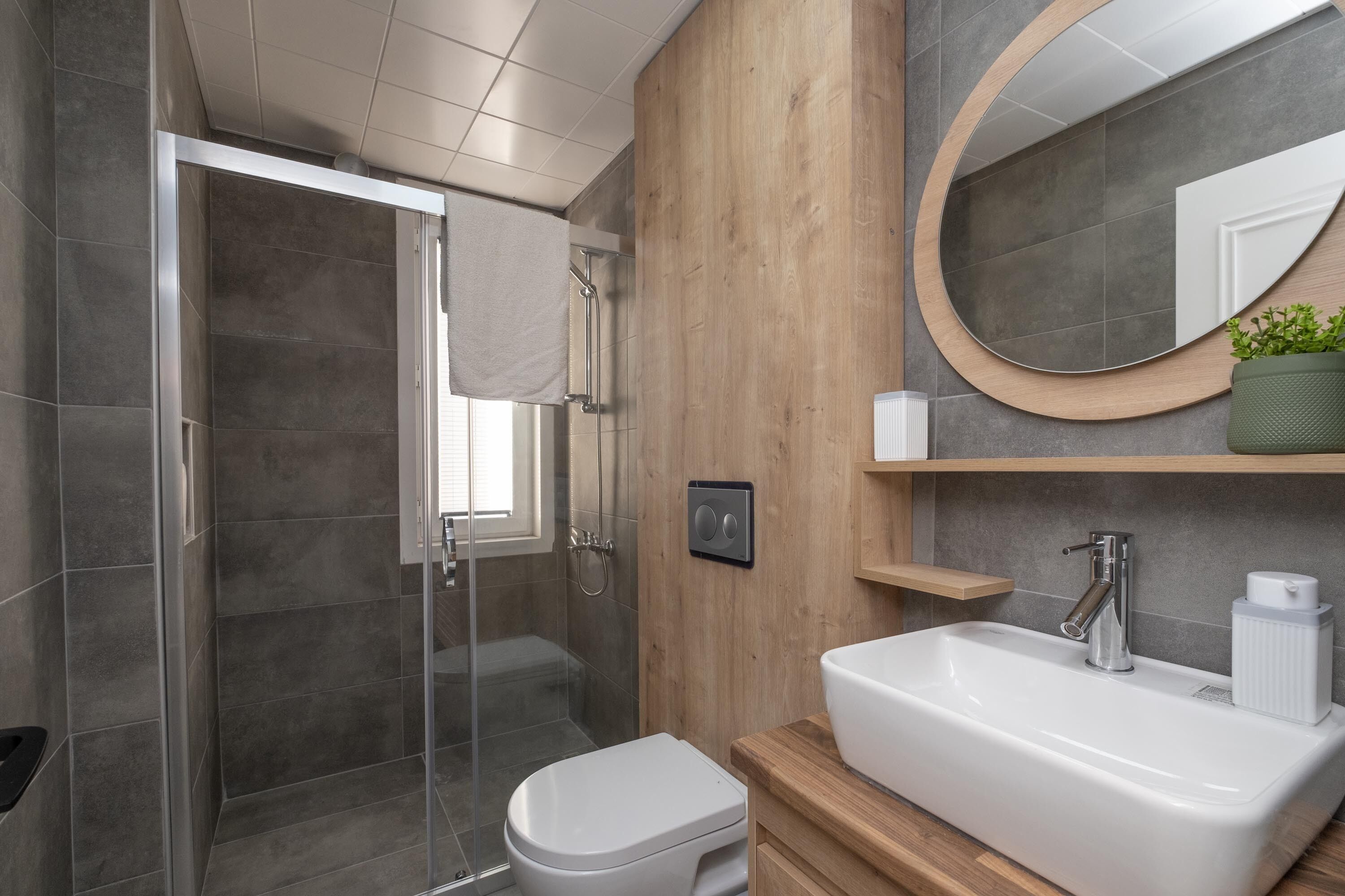Un baño moderno con ducha, inodoro y lavamanos.