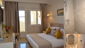Una habitación de hotel con cama, mesita de noche y zona de ducha.