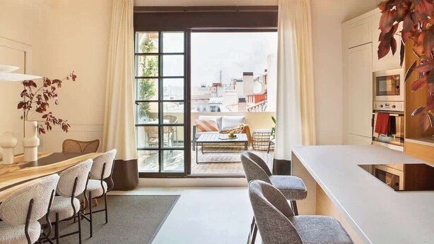 A modern kitchen with a large window, a dining area with chairs, and a view of the cityscape. - New-Beautiful Rooftop Apartment (Madrid)