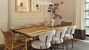 A dining area with a wooden table, six chairs, a hanging light fixture, and two framed artworks on the wall. - New-Beautiful Rooftop Apartment (Madrid)