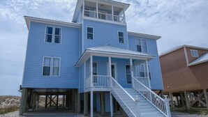 Un bâtiment à deux étages doté d’un balcon à l’étage supérieur, d’un porche couvert au rez-de-chaussée et d’un escalier menant à l’entrée.