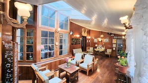 Una posada tradicional con interiores de madera, ventanas amplias y una zona de estar acogedora.