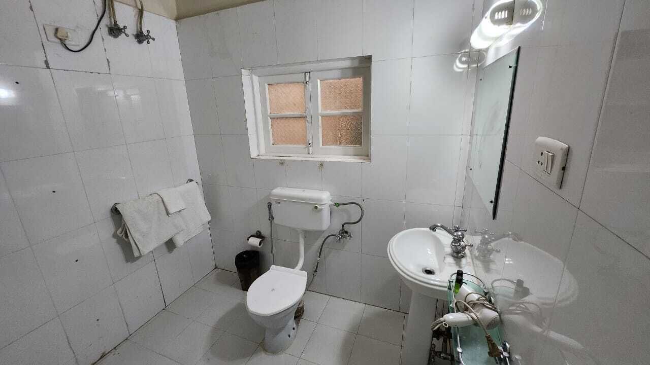 Une petite salle de bain propre, équipée de toilettes, d’un lavabo et d’une fenêtre.