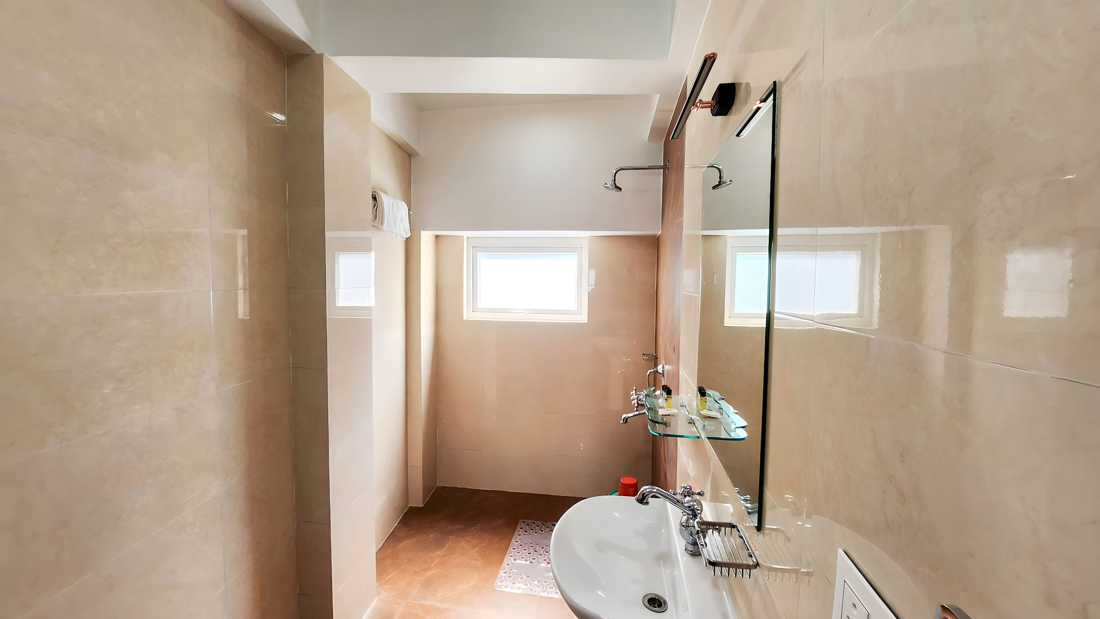 Un baño moderno con un espejo grande, un lavabo y una zona de ducha.