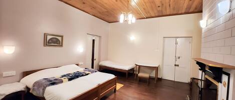A bedroom with a wooden ceiling, a bed, a bedside table, a chair, and a small table.
