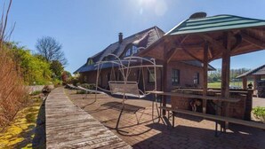 Una casa de madera rústica con un área de estar al aire libre techada y un columpio.