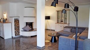Uma sala de estar moderna com lareira, sofá, mesa de centro e luminária de chão.