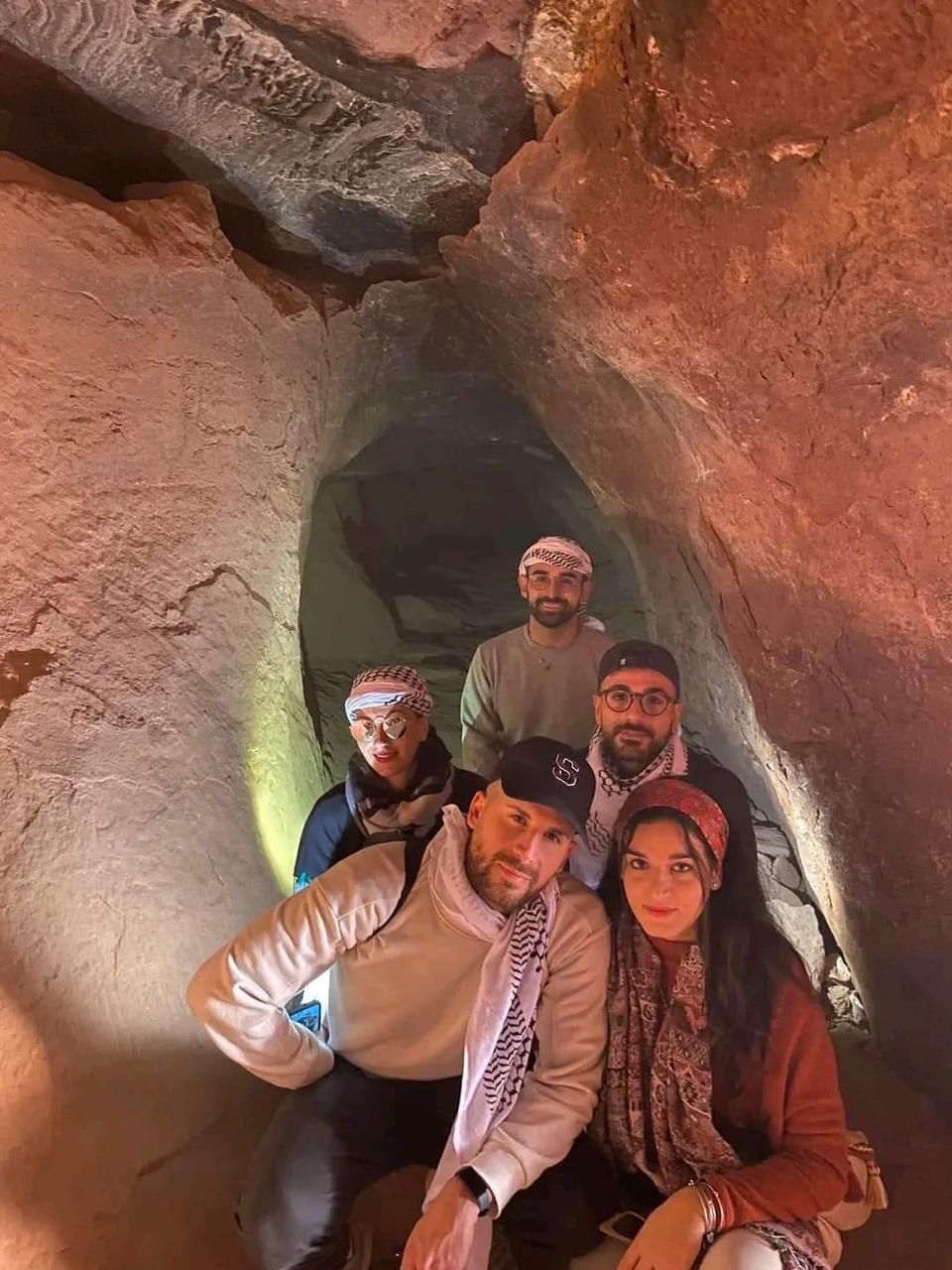 Un grupo de personas dentro de una cueva con formaciones rocosas naturales.
