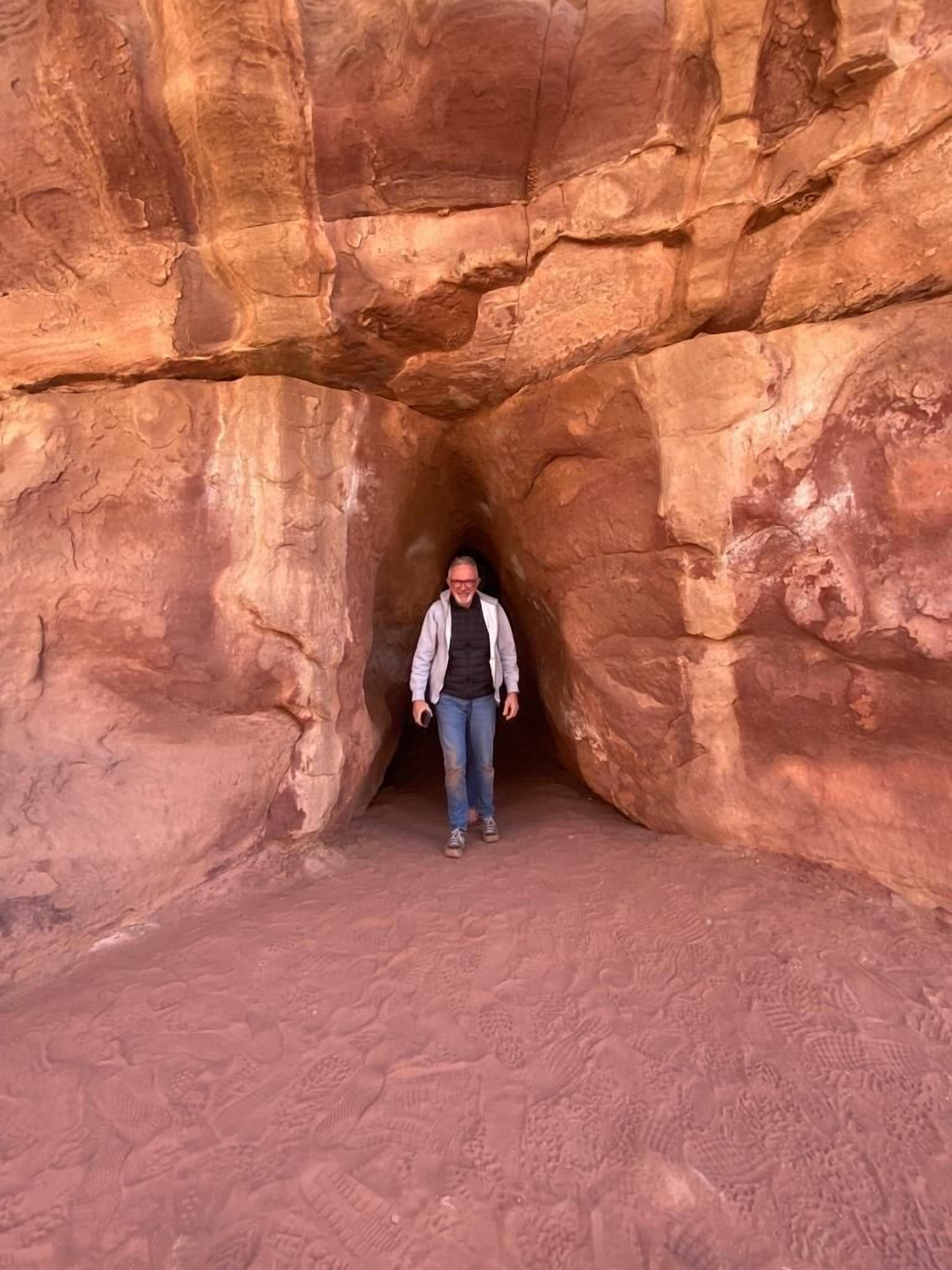 A person standing in a narrow, rocky passageway.