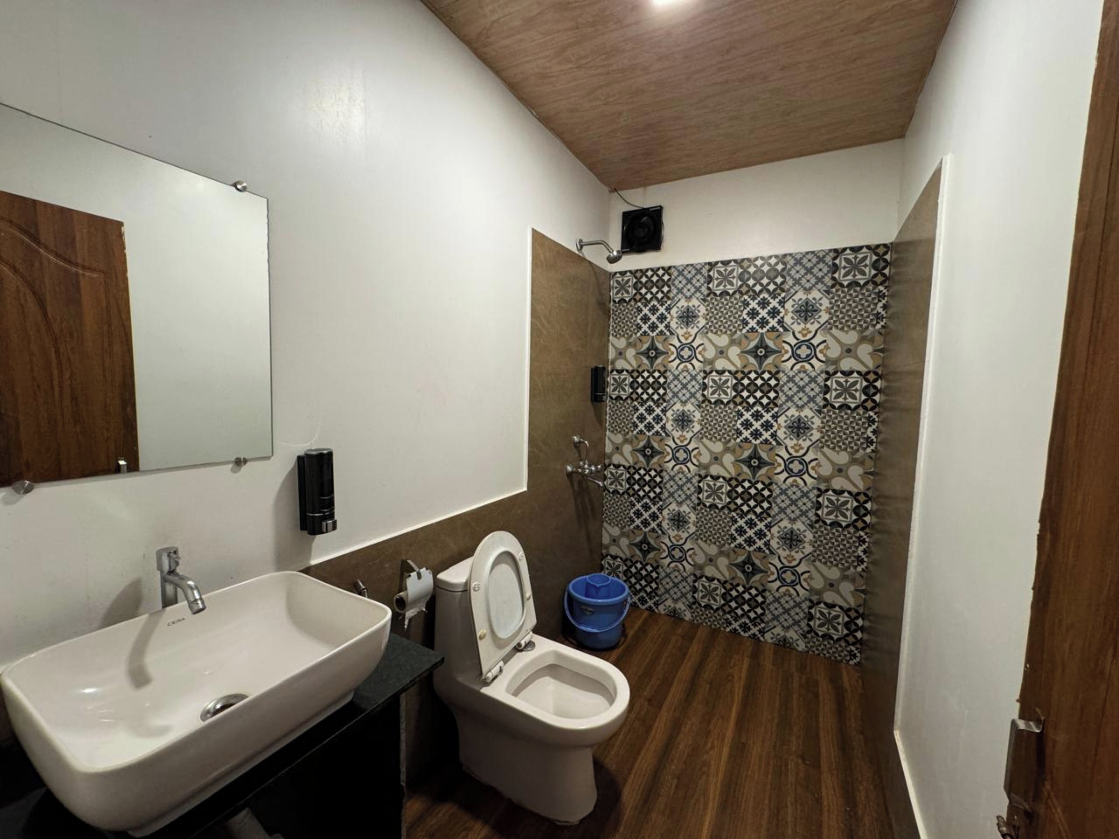 A bathroom with a sink, toilet, and shower area.