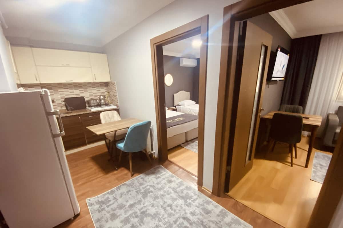 Quarto de hotel compacto com cozinha compacta, área de refeições e uma cama.