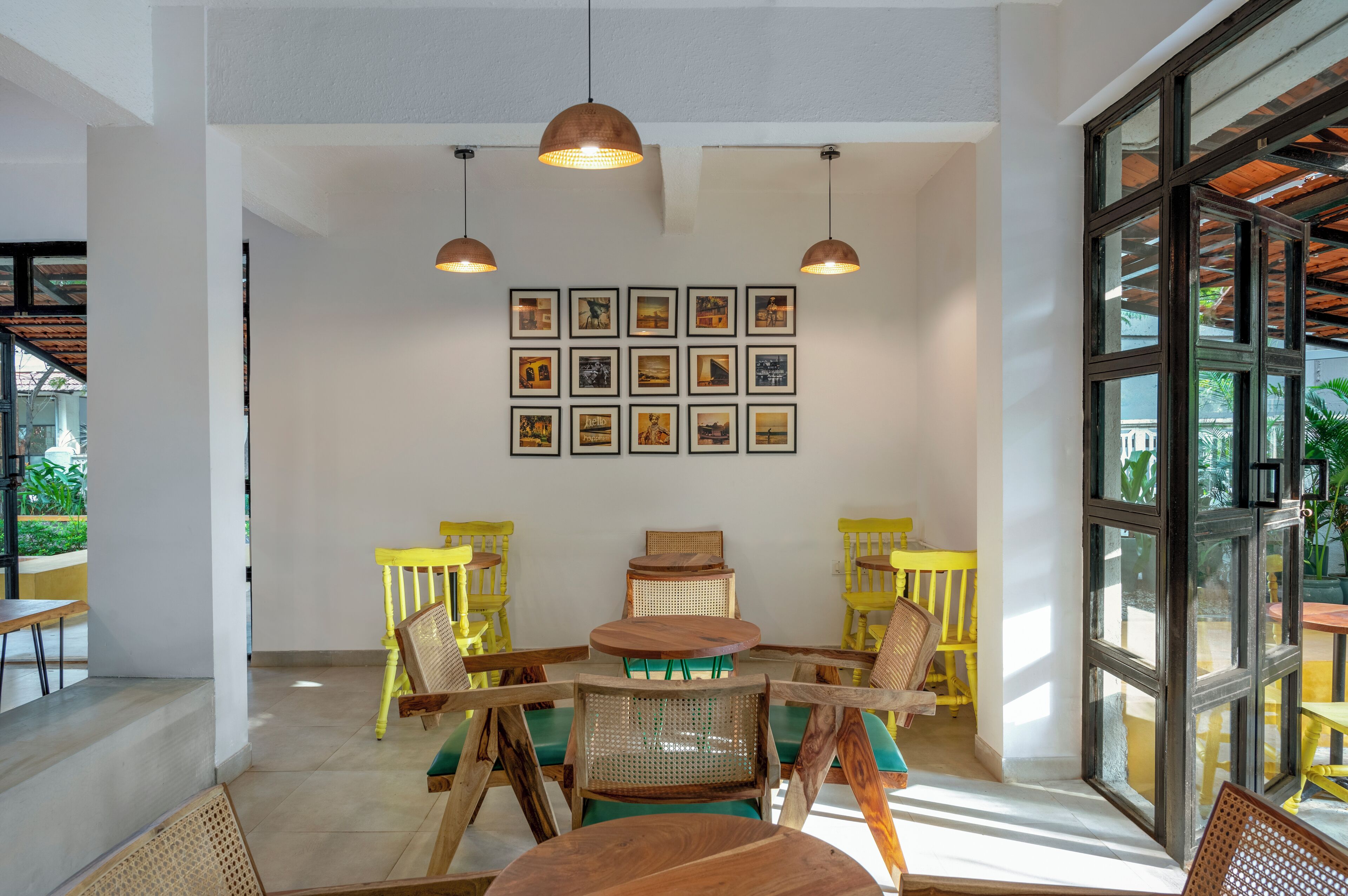 Un comedor con una mesa y sillas, cuadros en la pared y ventanas amplias.