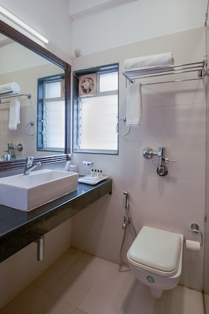 Enjoy a refreshing shower in the bathroom, featuring a sink, mirror, and shower area with handheld showerhead.