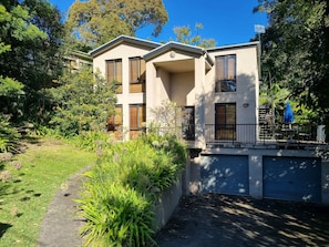 Ein zweigeschossiges Wohnhaus mit überdachter Terrasse und Garage.