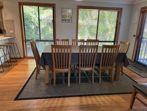 Un coin repas avec une table ronde, des chaises en bois et une nappe noire.