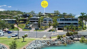 Ein Hotel an der Küste mit Parkplatz, Meerblick und einem Schild für Whitsunday Vacations.
