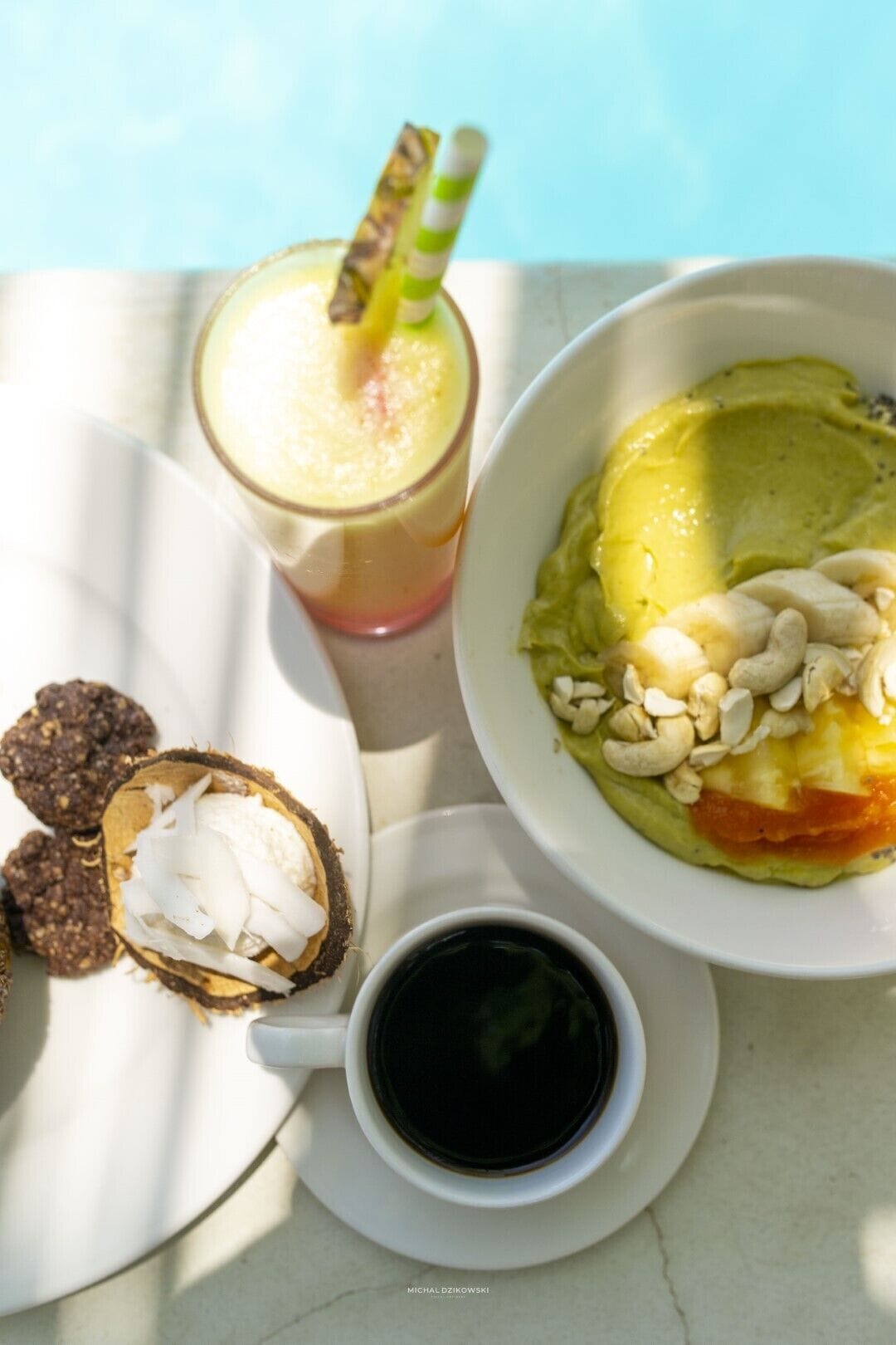 A table with a plate of food, a drink, and a bowl of dessert.