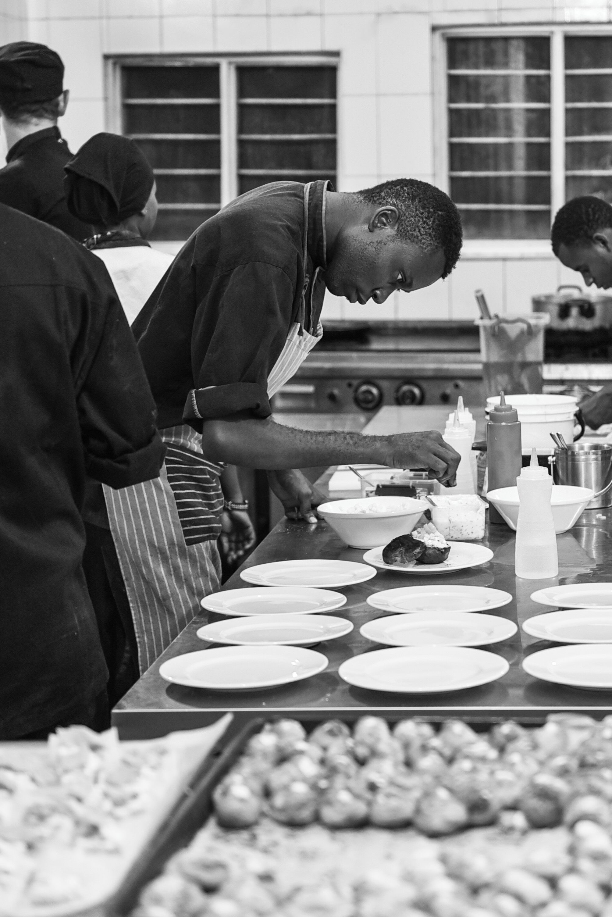 Une cuisine où plusieurs chefs préparent les plats.