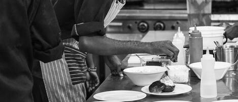 Une cuisine où plusieurs chefs préparent les plats.