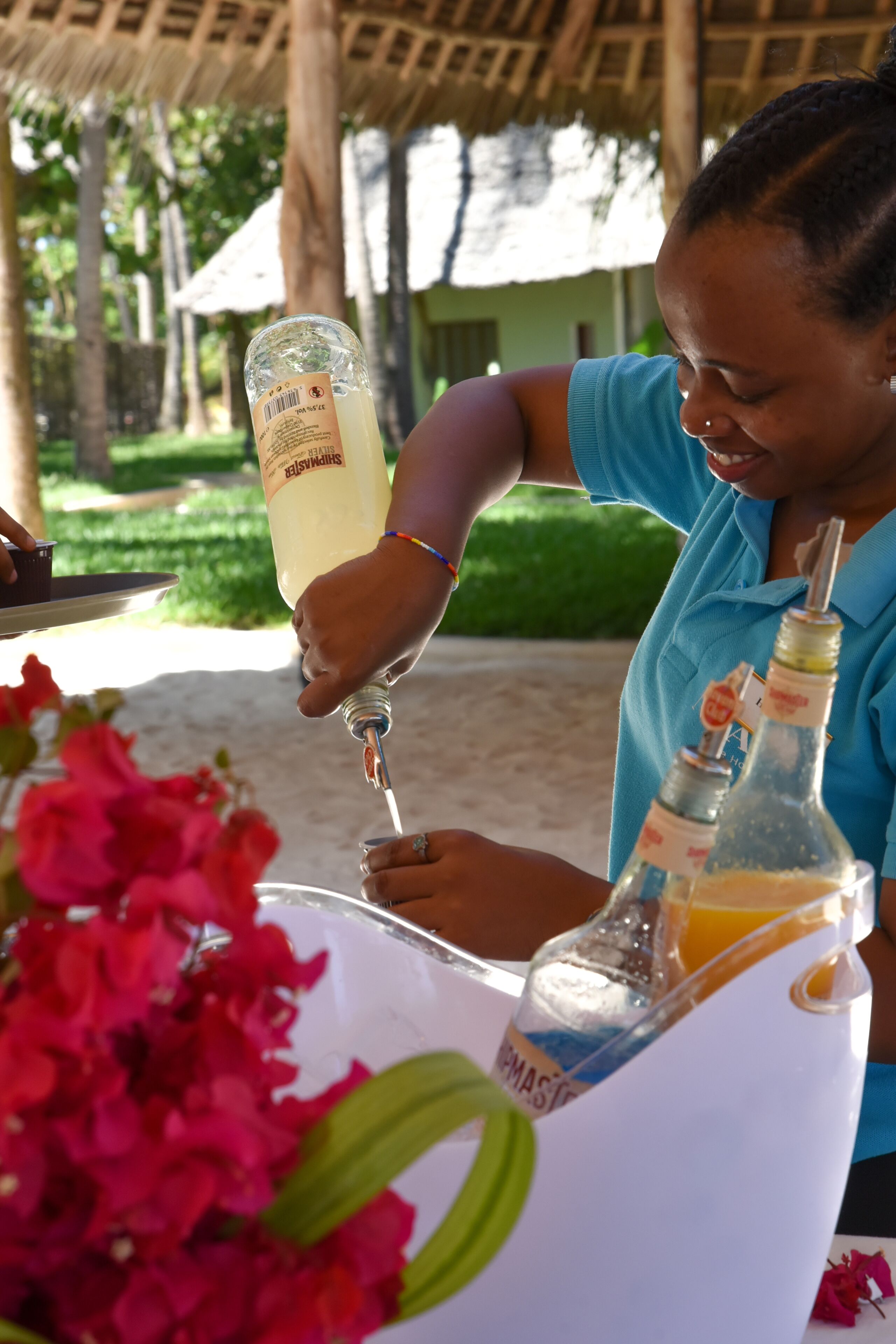 A person pouring a drink from a bottle into a glass.