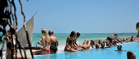 Una piscina al aire libre, sombrillas, sillones reclinables de piscina