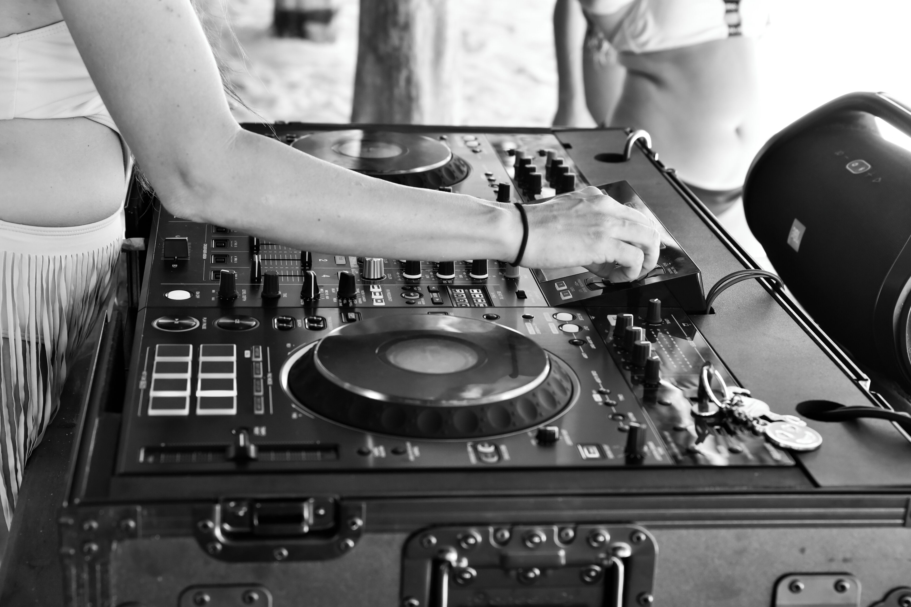 A DJ booth with a mixer, turntables, and a subwoofer.