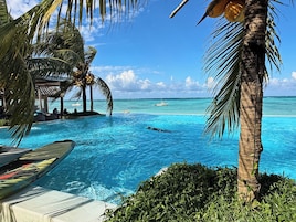 A clear blue pool with a view of the ocean and a boat in the distance.