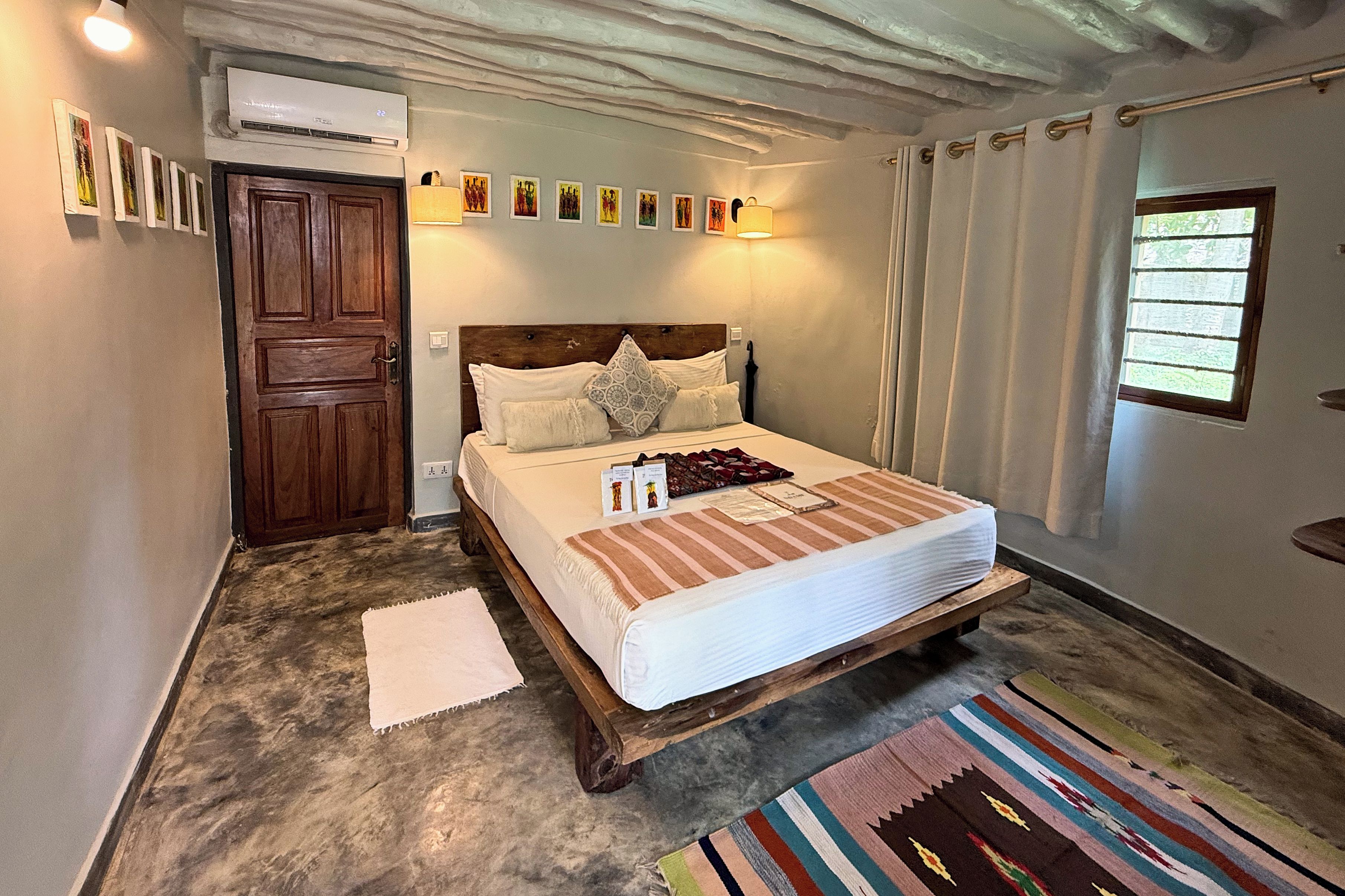 Une chambre avec un lit en bois, un tapis blanc et une fenêtre avec des rideaux.