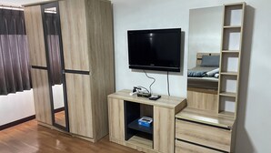 A room with a wardrobe, a TV, a small cabinet, and a mirror. - Muangthong C3, C4 near Impact by Anna (Pak Kret)