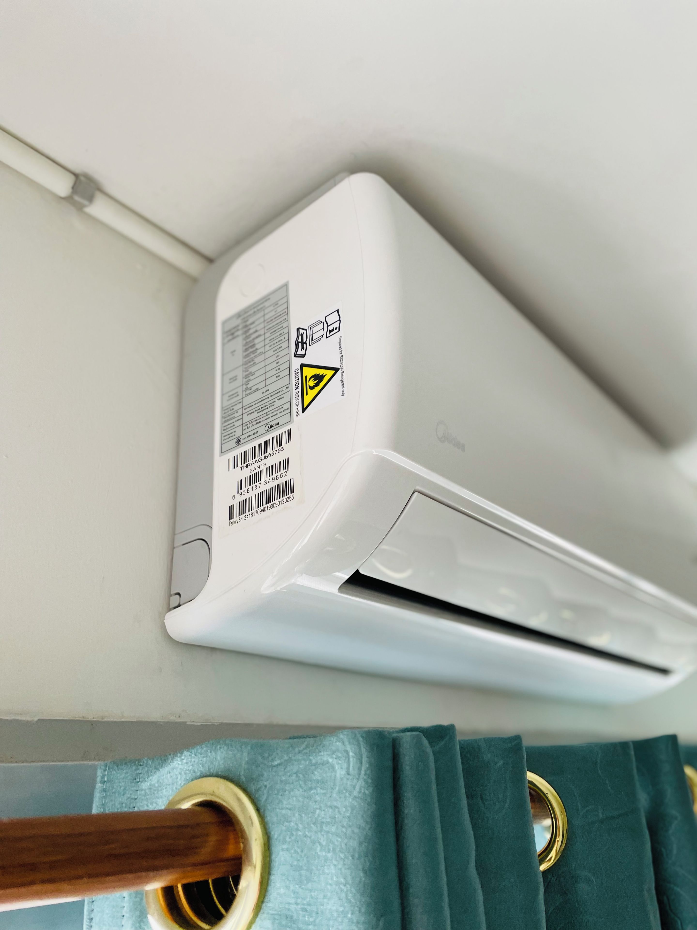 Eine an der Wand befestigte Klimaanlage mit Etikett und Barcode.