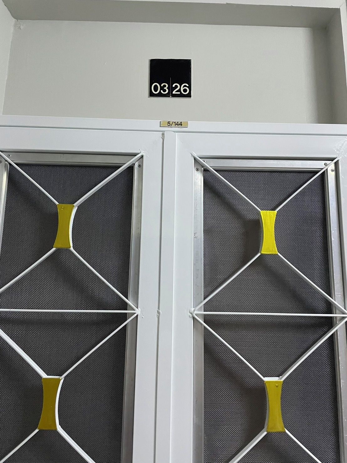 A double door with a number sign above it and a label below.
