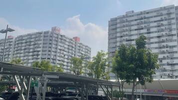 A parking structure with a fire exit sign, surrounded by trees and buildings in the background.