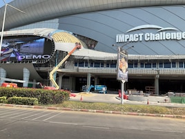 Un edificio grande con techo curvo y la frase "IMPACT Challenge" en la fachada.