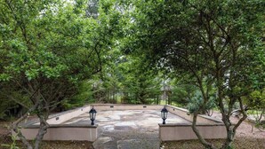 A stone pathway leading to a seating area surrounded by trees. - Pebble Beach's Los Altos (Pebble Beach)