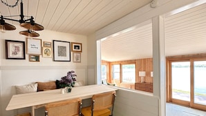 A dining area with a wooden table, four chairs, and a hanging light fixture. - The Darling Cabin, 60's Charm + Modern Flair (Alexandria)
