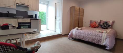 A bedroom with a bed, a wardrobe, a desk, and a chair.