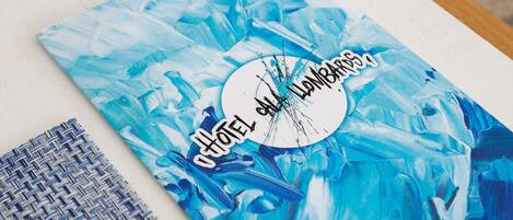 Un folleto de hotel con un diseño abstracto azul y el texto 'HOTEL LAMPSONS'.