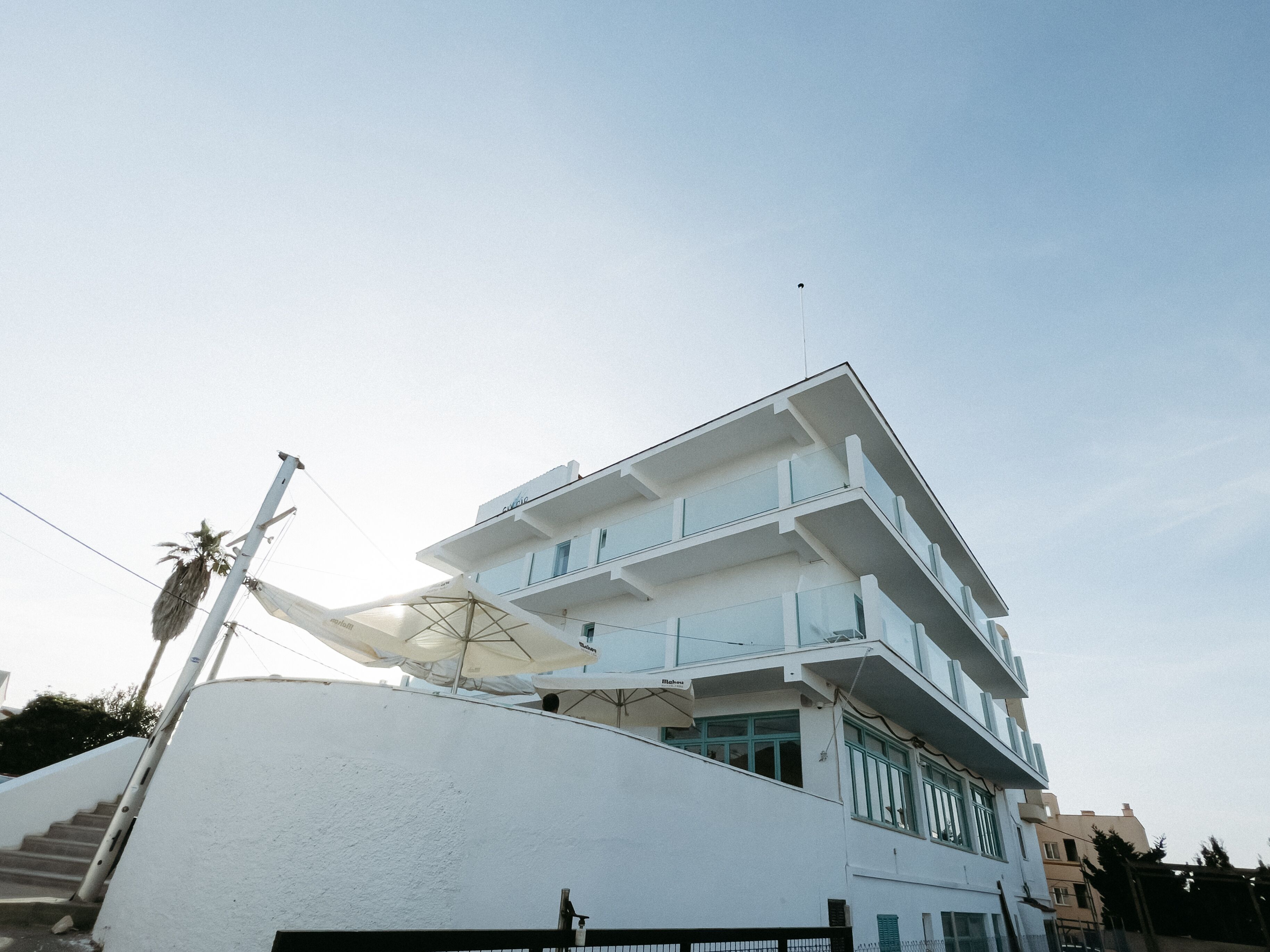 Un edificio de varios pisos con balcones y una antena parabólica.