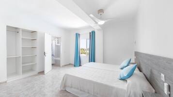 A bedroom with a bed, a wardrobe, and a ceiling fan.