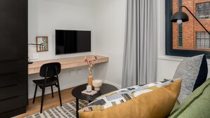 A modern room with a desk, chair, and a bed with patterned pillows. - Cozy Studio by Table Mountain Explore Cape Town (Cape Town)