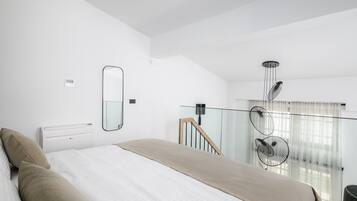 Une chambre moderne avec un grand lit, un miroir, un ventilateur de plafond et une vue sur un balcon.