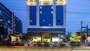 A modern hotel with a prominent entrance and a sign indicating it is a hotel.