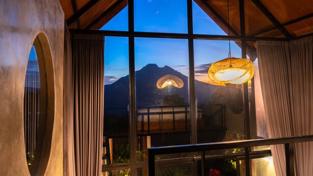 Una habitación con ventanas amplias, techo de madera y una lámpara colgante.