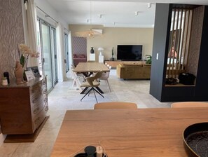 Enjoy a comfortable stay in this stylish living space with a dining area, sofa, and mounted TV.