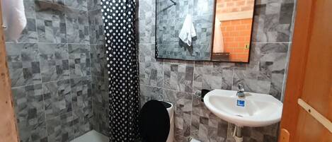 A bathroom with a shower, toilet, and sink.