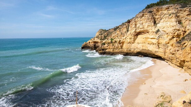 A coastal beach with a rocky cliff and clear blue sea. - 102 Hibiscus Monte Dourado (Carvoeiro)